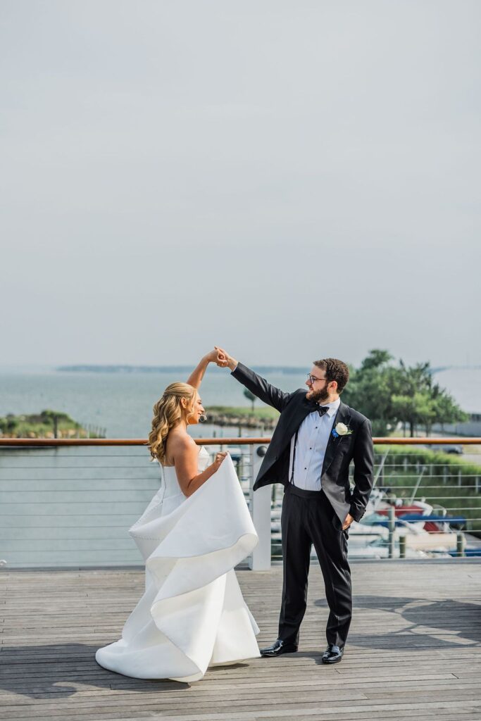 Bride and groom dance on balcony overlooking Peconic Bay